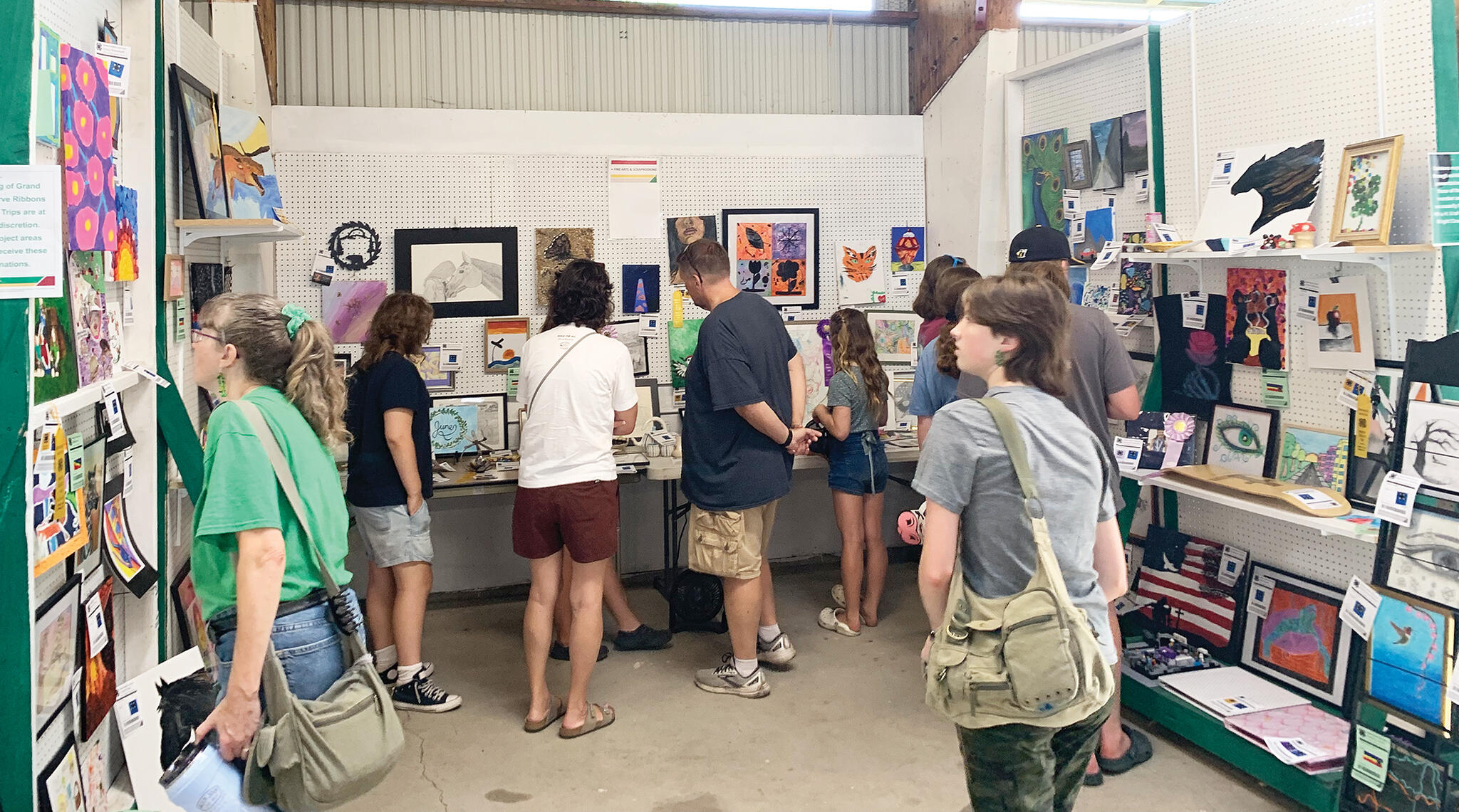 Fairgoers study the detailed work of local artists and crafters in the 4-H building.