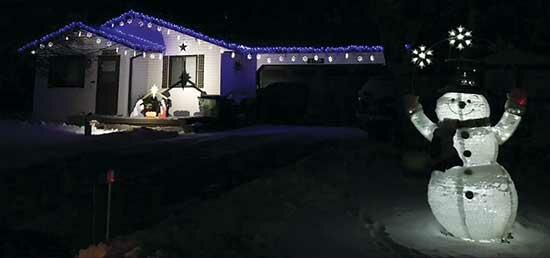 This snow-themed decorated home fits in with the Minnesota weather. Snowflake lights trim the home and a fully lit snowman smiles in the front yard at anyone who passes by this beautifully decorated home. Also displayed is a wood nativity scene brightly lit and visible from the street in Monticello. (Photo by Emily Vojtech)