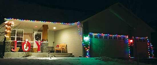 A string of colorful lights is strung along this Monticello home. On the front porch, a large ‘JOY’ sign sits under the bright lights. Notice the nativity scene in the center of the letter ‘O’. (Photo by Emily Vojtech)