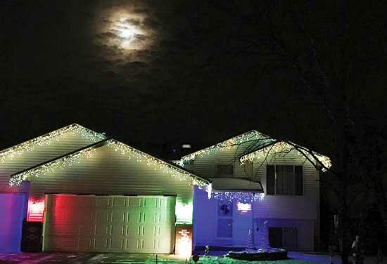A bright variety of Christmas lights illuminate this home on a moonlit night in the Monticello Township. (Photo by Emily Vojtech)