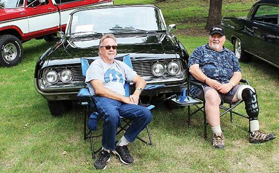 Steve Koltes, of Blaine, left, enjoyed the day with car owner Jim Lund, right, of Plymouth, camping out in front of the 1962 Dynamic 88 Oldsmobile. (Photo by Shelby Hulstein)