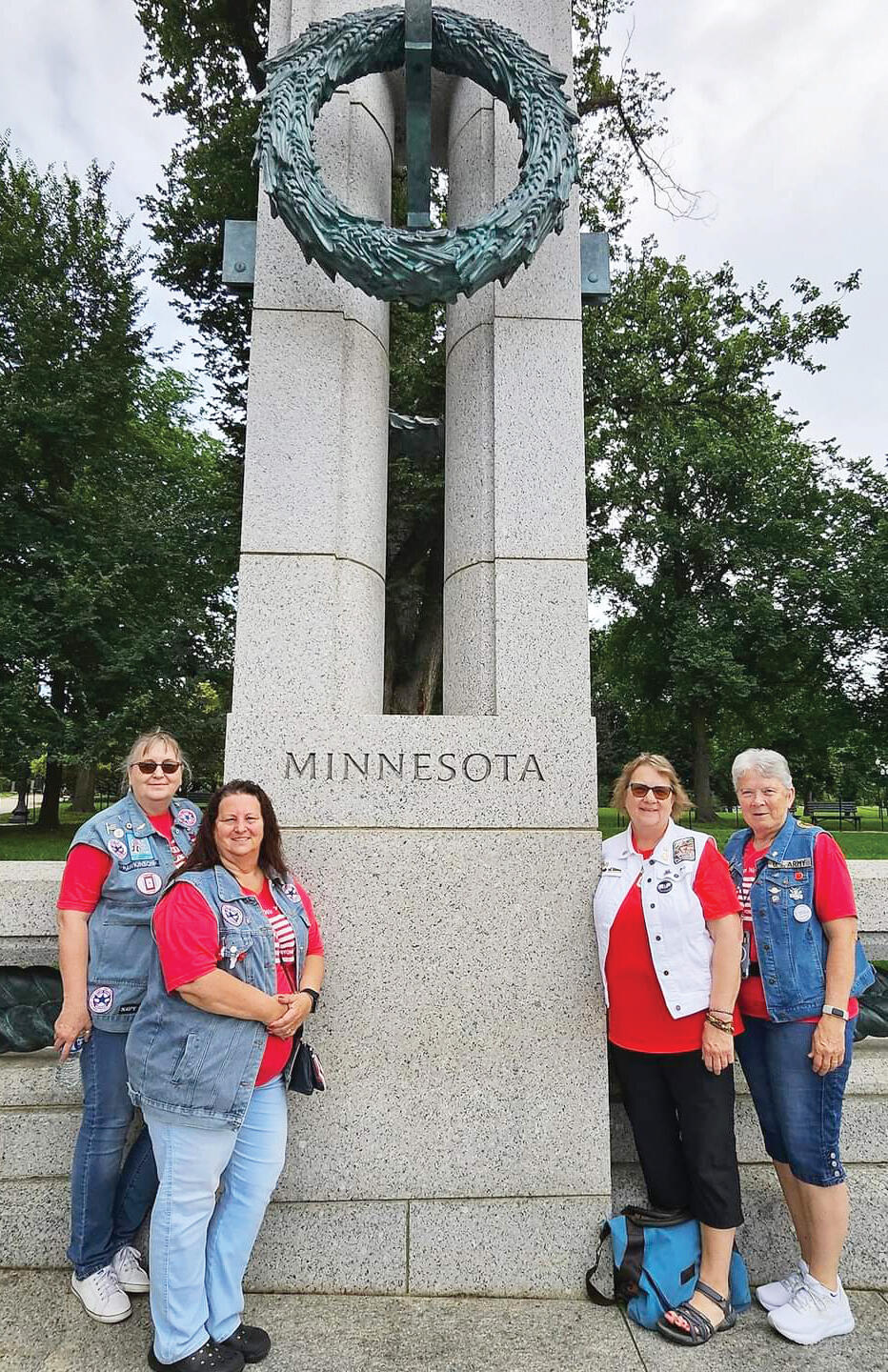 Four members from Minnesota pose in front of the Minnesota pillar at the WWII Memorial. From left, Terri Hawkinson, Jen Pecarina, Mary Johnson, and Jeanne Ullmer.
