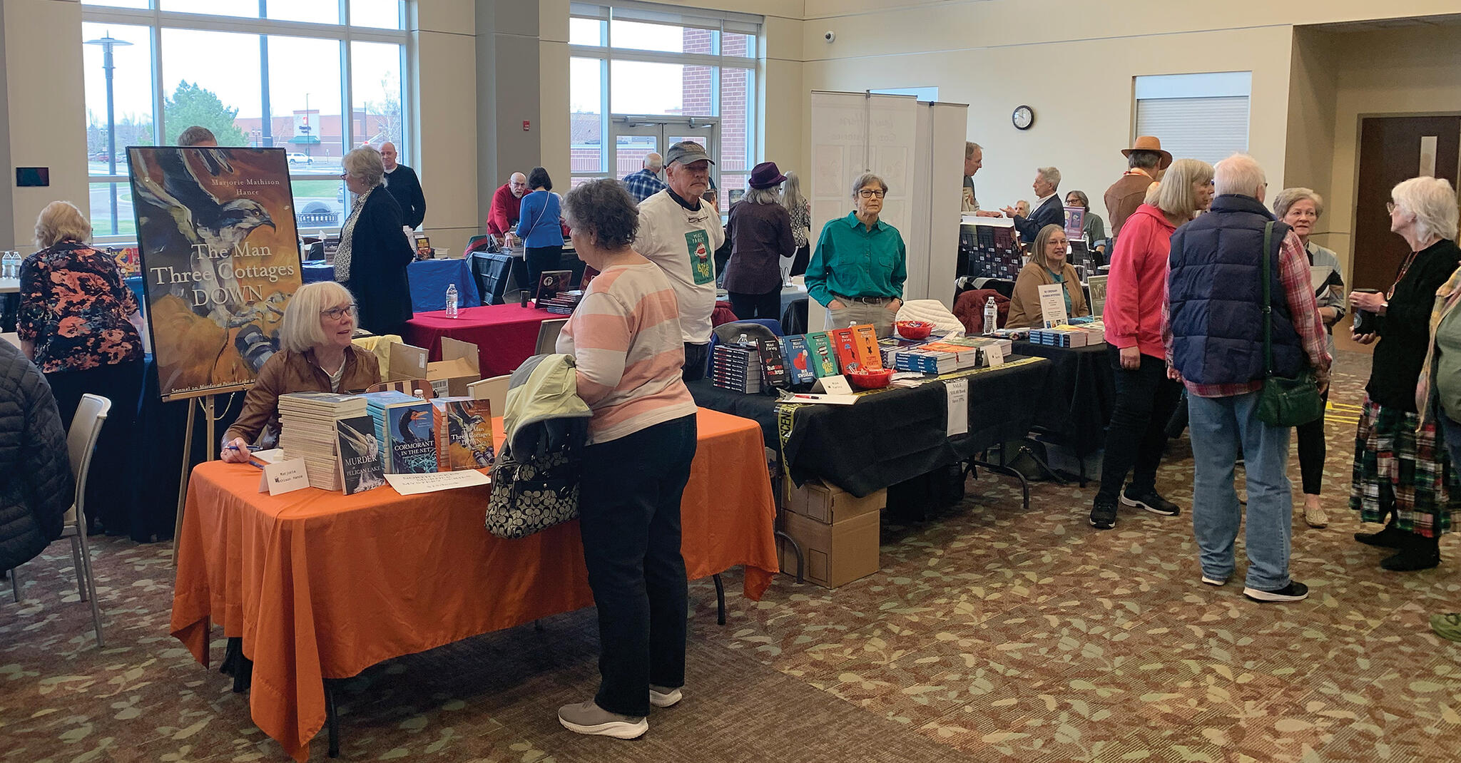 Book enthusiasts chat with local authors and purchase signed books at the Sisters in Crime book festival in St. Michael on Saturday, April 20.