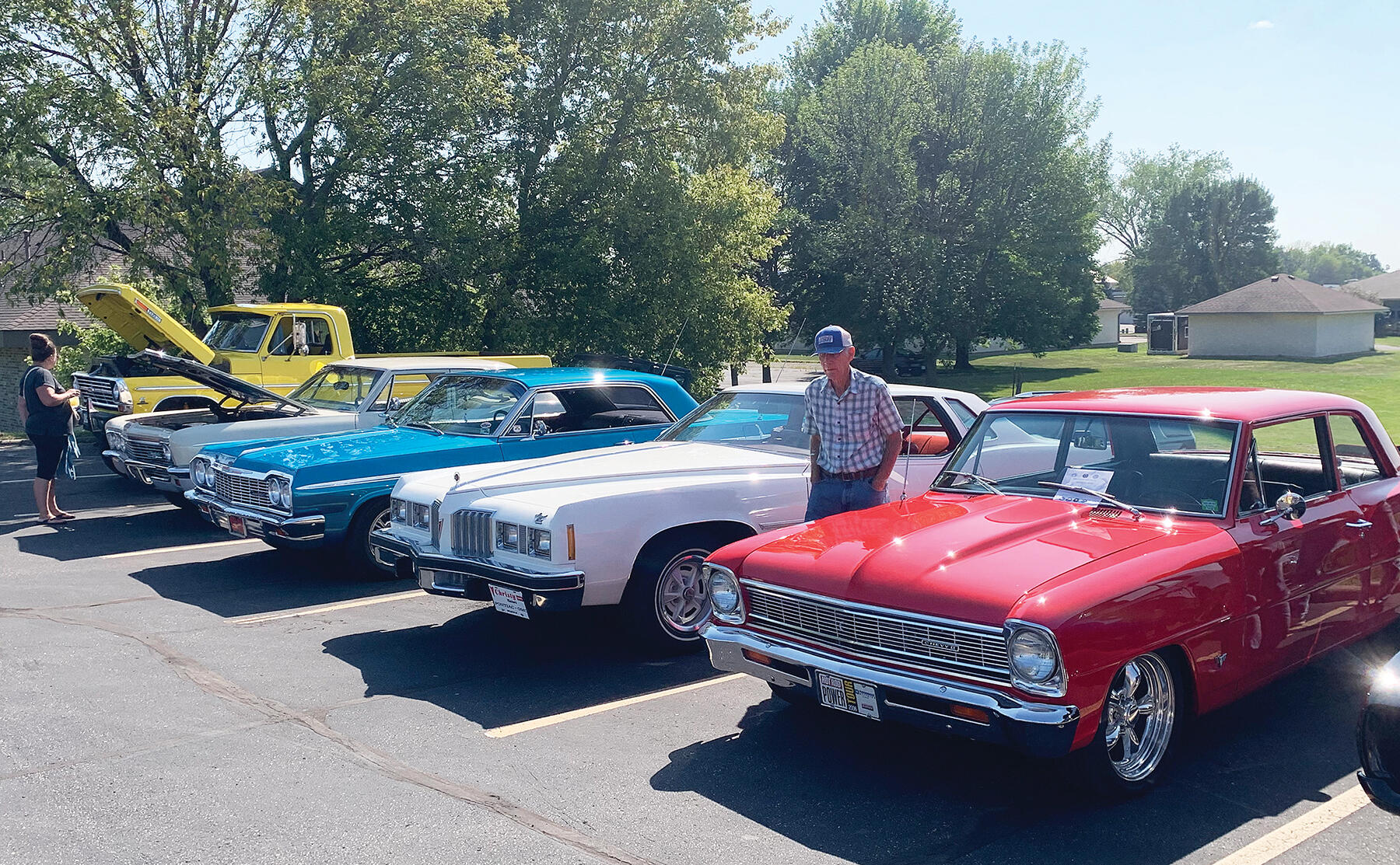 Classic cars lined up in a patriotic red, white, and blue.