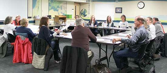 Photo of the Launch Committee at their Nov. 15 meeting in a future classroom for the Impact Christian Academy. The meeting was led by Mary Blosser, who is now retired and focuses on the academy. Here members are pictured having an open discussion about plans for the school.